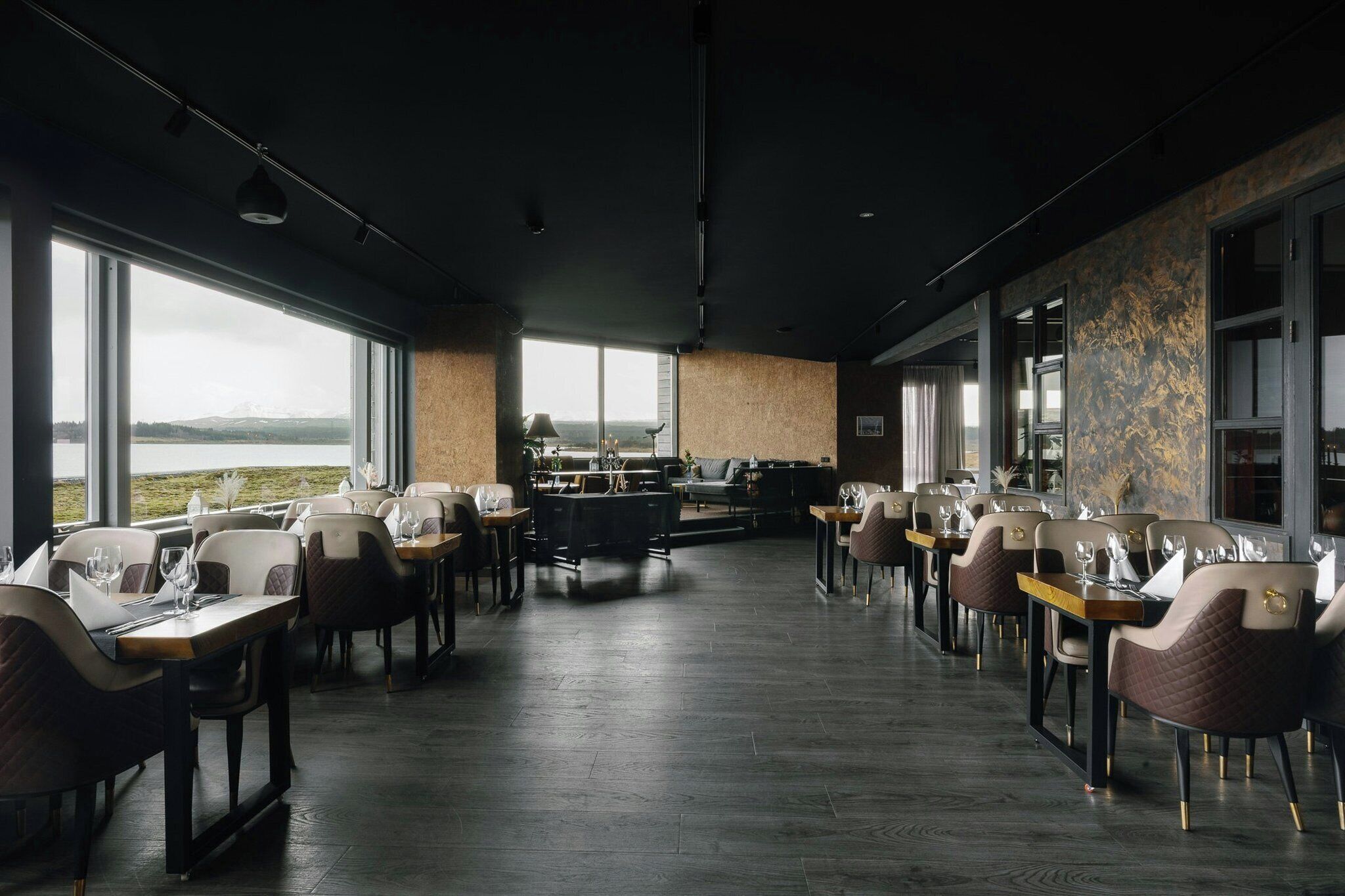 Un restaurant doté d’une grande salle à manger, de larges fenêtres et offrant une vue sur le paysage.