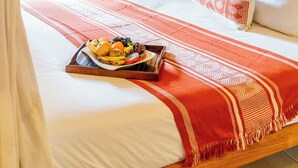 A bedroom with a canopy bed, a tray of fruit, and a view of the outdoors.