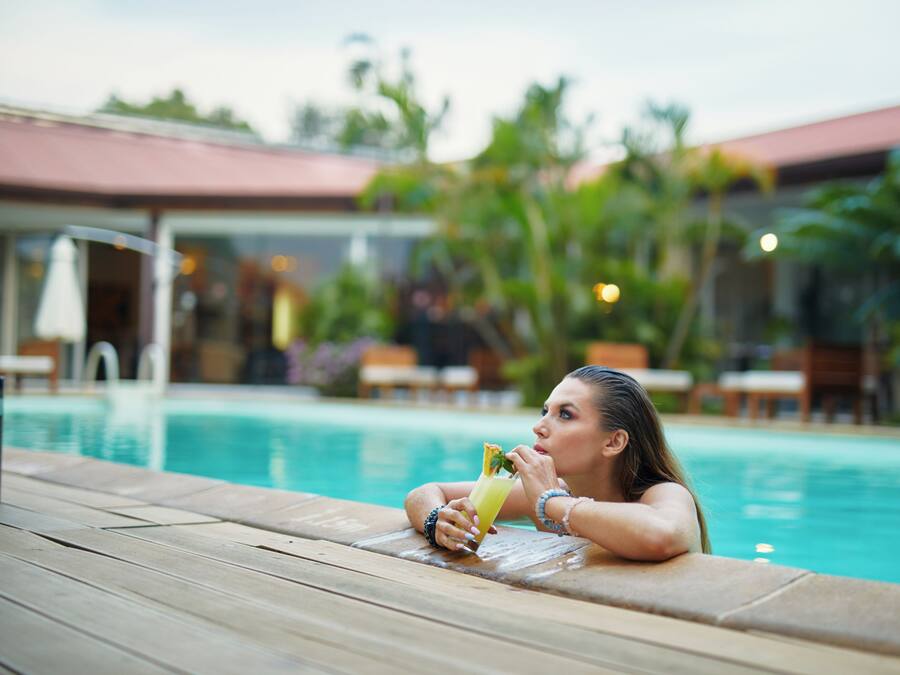 Una piscina al aire libre, sombrillas, tumbonas