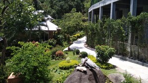 A landscaped garden with a pathway, a gazebo, and a partially constructed building. - Tanote Villa (Koh Tao)