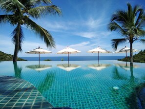 Una piscina al aire libre, sillones reclinables de piscina