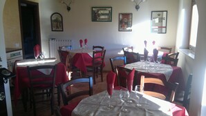A dining area with tables set for two, chairs, and wine glasses. - Rifugio del Pettirosso (Pescasseroli)