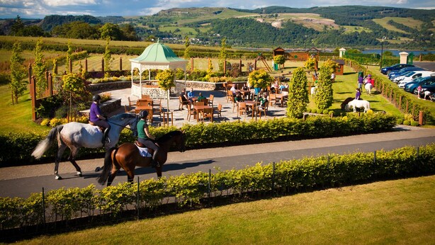 A horse riding area with a gazebo, outdoor seating, and a parking lot. - Ingliston Country Club Hotel (Bishopton)