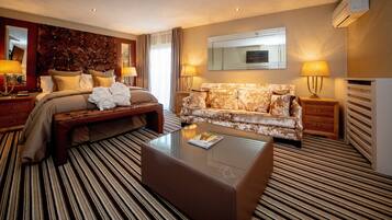 Een hotelkamer met een bed, een bank, een bijzettafeltje en een spiegel.