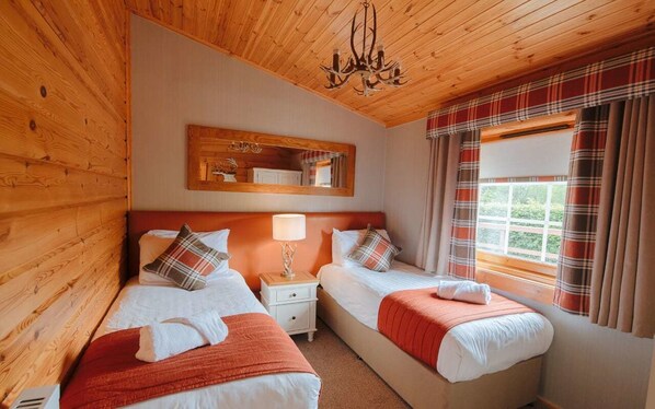 A wooden-paneled room with two beds, a nightstand, a mirror, and a window with curtains. - Ingliston Country Club Hotel (Bishopton)