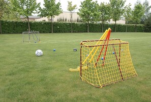 A grassy outdoor area with a soccer goal, a smaller goal, and a netted play area. - Hotel Grodzki (Poznań)