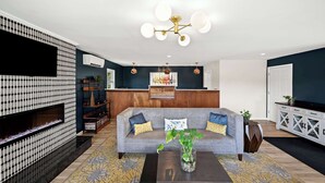 A modern living room with a grey sofa, a coffee table, and a decorative plant. - Best Western Freeport Inn (Freeport)
