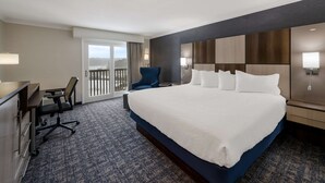 A hotel room with a large bed, a desk with a chair, a balcony with a view, and a modern design. - Best Western Freeport Inn (Freeport)