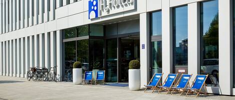 A modern hotel with a prominent logo, large windows, and a clean entrance.