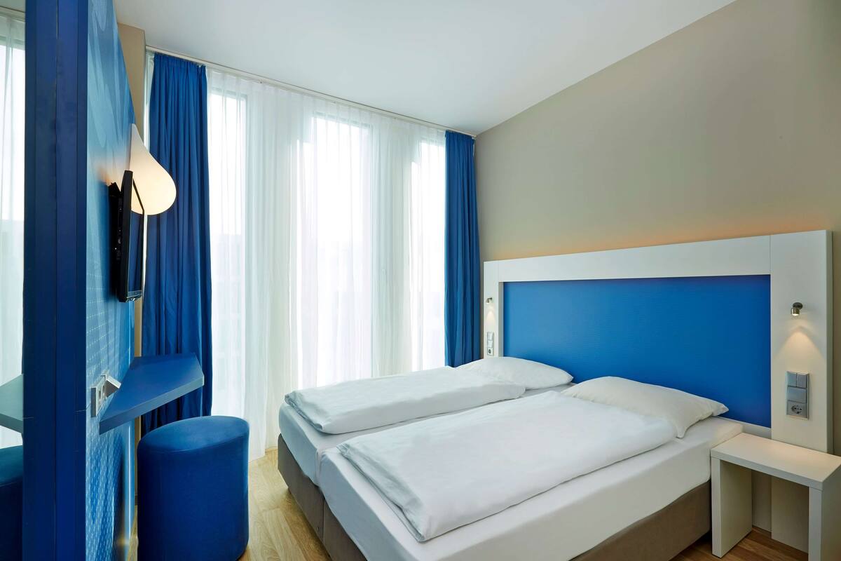 Una habitación de hotel con dos camas, un escritorio y una silla.