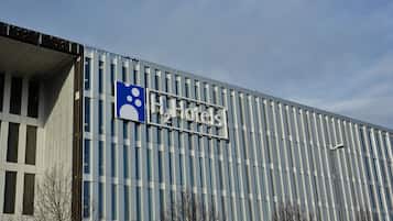A modern building with a sign for "2 Hotels" and a blue wheelchair accessibility symbol.