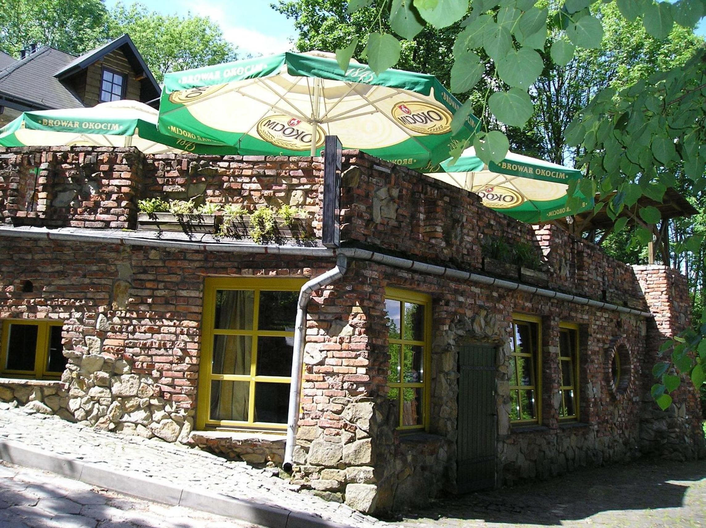 Un bâtiment en pierre doté de nombreuses fenêtres et d’une entrée en briques.