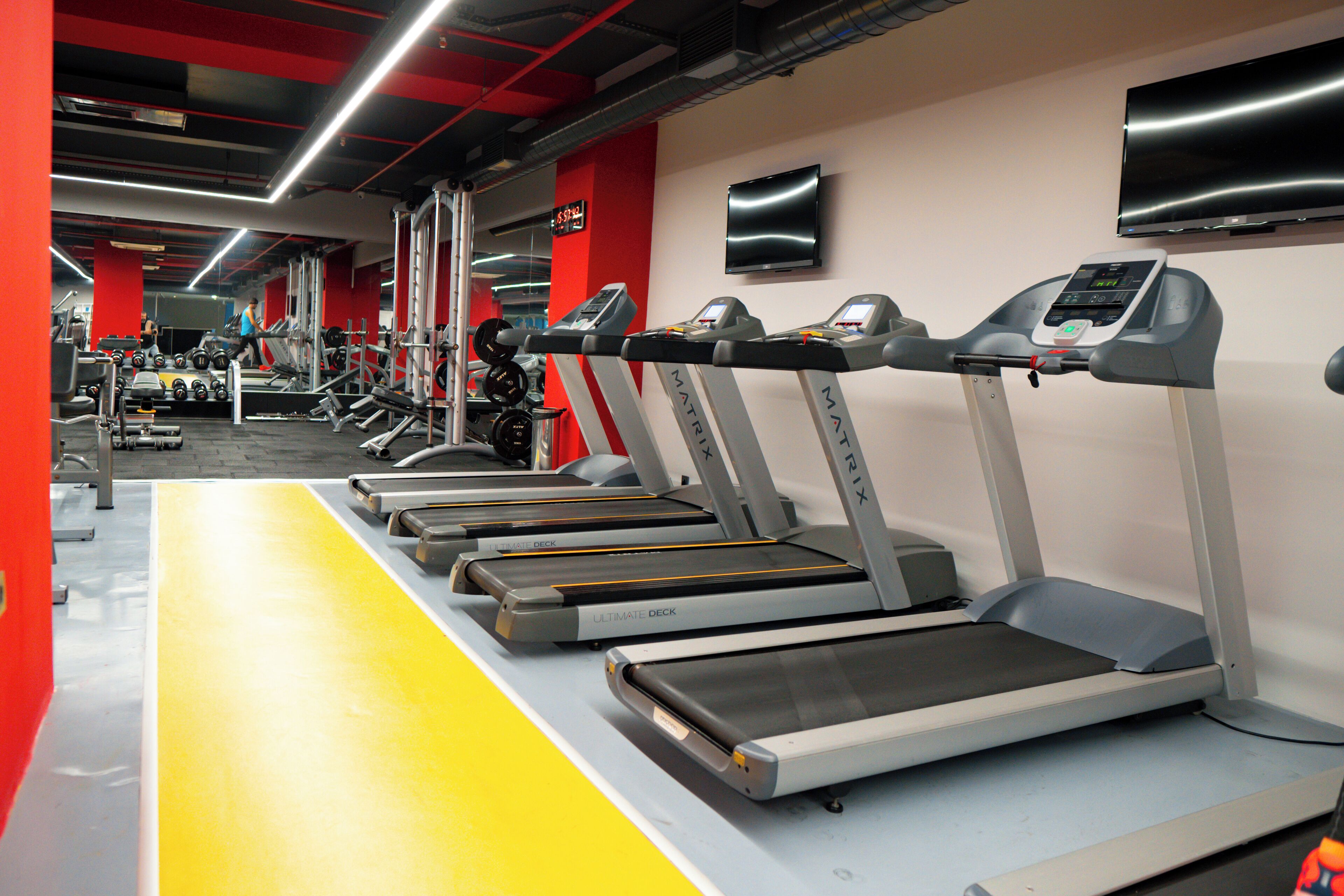 Un gimnasio con cintas de correr, pesas y máquinas de ejercicio.