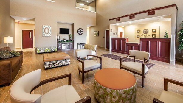 A spacious lobby with a reception desk, seating area, and a kitchen in the background. - Comfort Inn Lexington South (Nicholasville)
