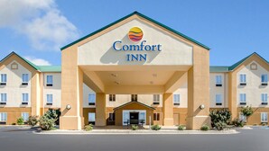 A Comfort Inn hotel with a central entrance, multiple floors, and a clear blue sky. - Comfort Inn Lexington South (Nicholasville)