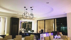 A modern interior with a bar area, seating, and large windows. - Hotel Esse Davao (Davao)