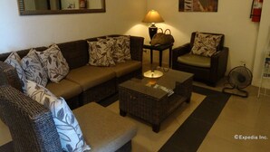 A living room with a sofa, armchairs, a coffee table, a lamp, a painting, and a fire extinguisher. - Hotel Esse Davao (Davao)