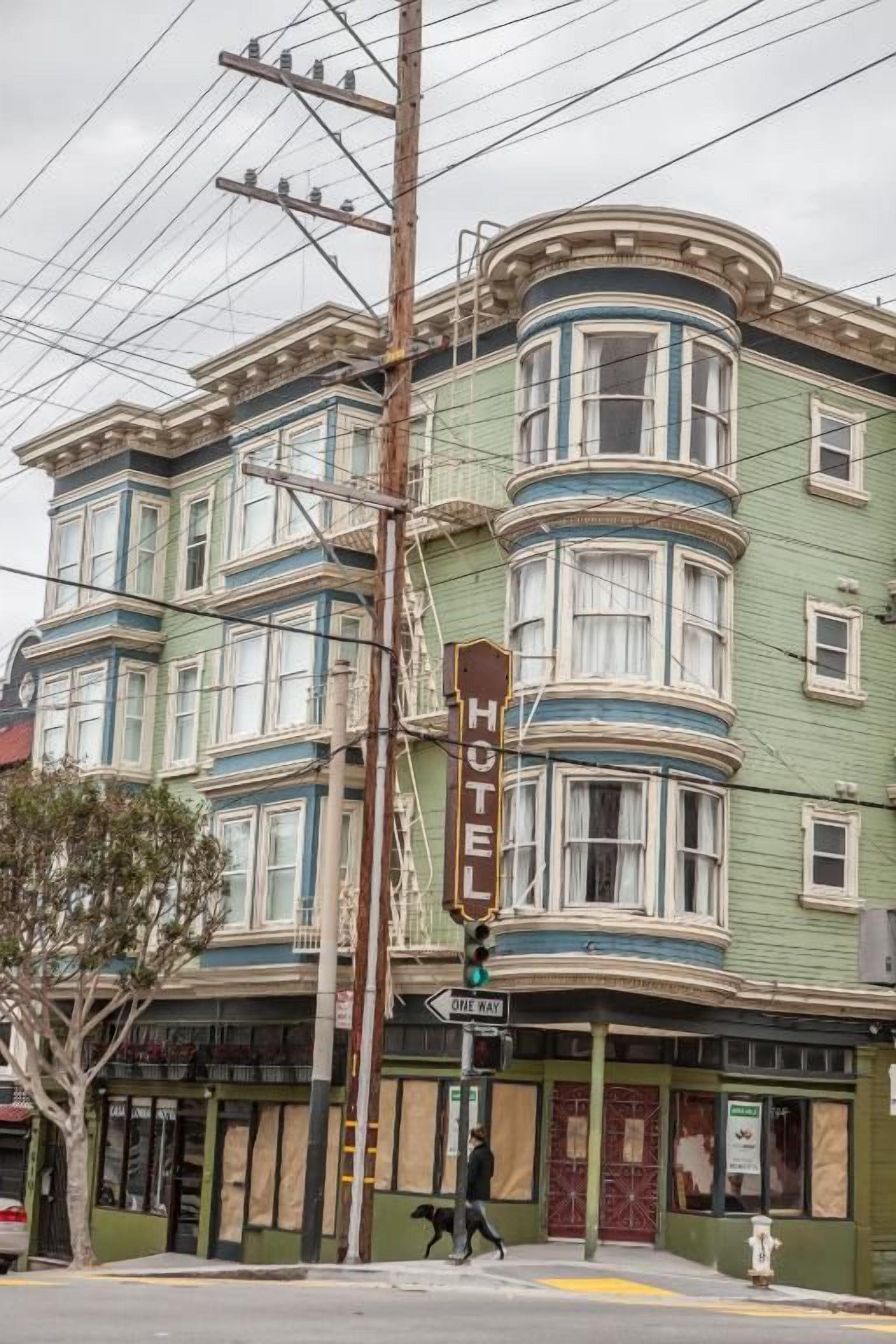 A historic building with a prominent 'HOTEL' sign, multiple windows, and a corner location.