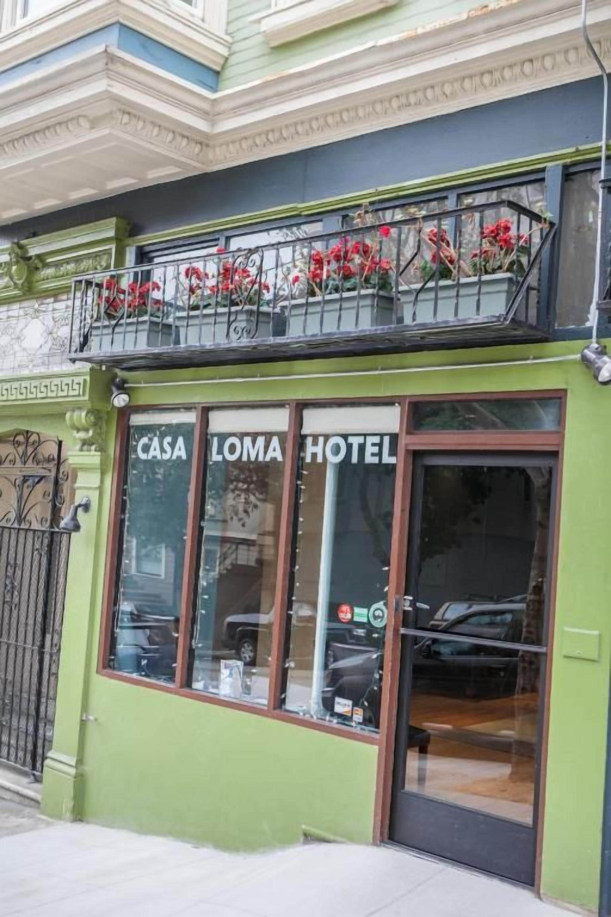 A building with a green facade and a sign that reads 'CASA LOMA HOTEL.'