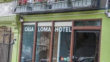 A building with a green facade and a sign that reads 'CASA LOMA HOTEL.'