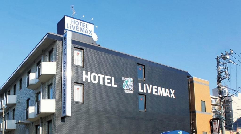 A building with a sign that reads 'HOTEL LIVEMAX' and a logo indicating it's part of the 'LIVEMAX GROUP'.