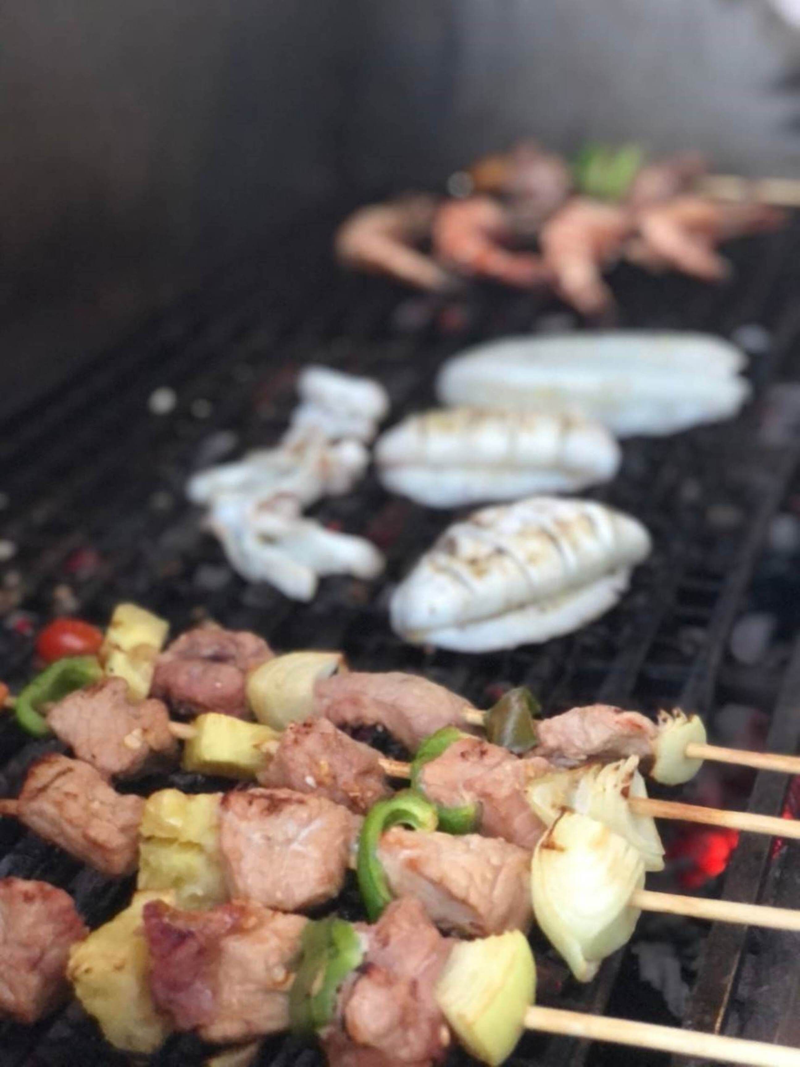 A grill with skewers of meat and vegetables.