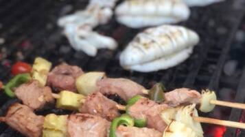 A grill with skewers of meat and vegetables.