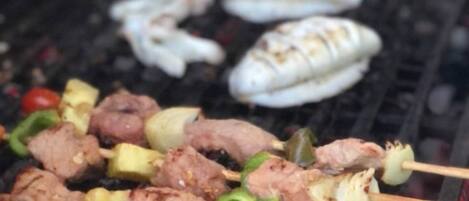 A grill with skewers of meat and vegetables.
