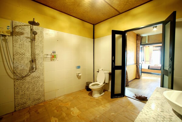 A bathroom with a shower, toilet, and sink.