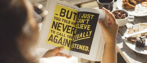 A person reading a book with a quote on the cover.