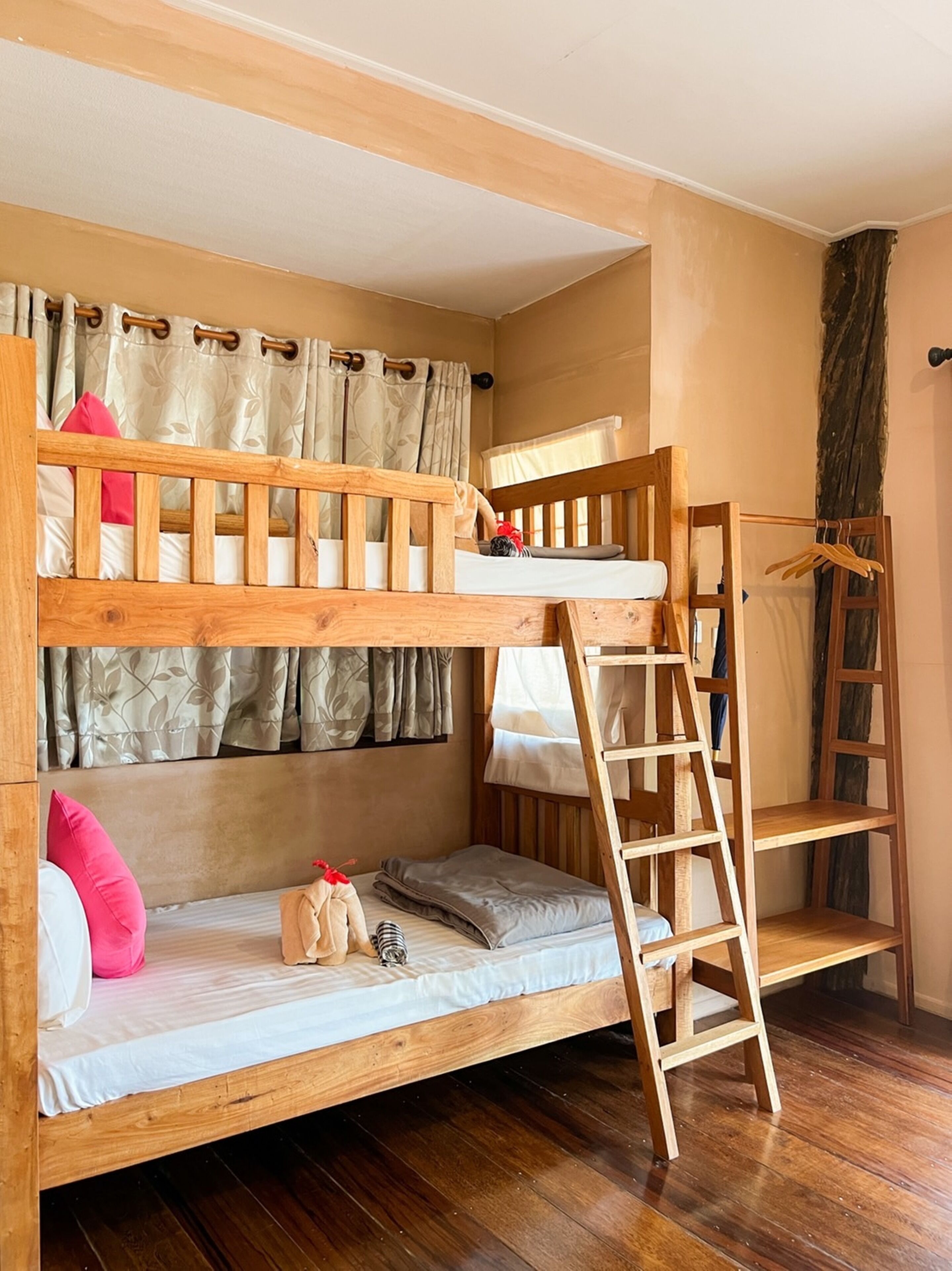 A bunk bed with a ladder, wooden headboard, and a small shelf.