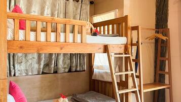 A bunk bed with a ladder, wooden headboard, and a small shelf.