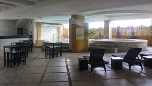 A spacious indoor area with a pool, seating, and a reception desk. - The Pinnacle Hotel and Suites (Davao)