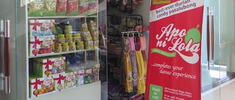 Una tienda con estantes llenos de productos envasados y un cartel promocional para Apo Ni Lolo.