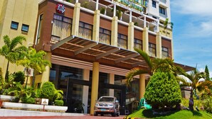 A multi-story hotel with a prominent entrance, balconies, and a clear blue sky. - The Pinnacle Hotel and Suites (Davao)