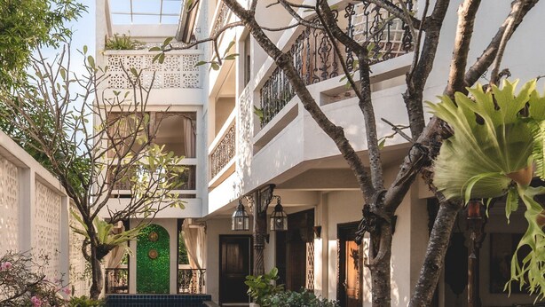 A courtyard with a wooden deck, outdoor seating, and a pool. - At Niman Conceptual Home (Chiang Mai)