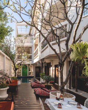 A courtyard with a wooden deck, outdoor seating, and a pool. - At Niman Conceptual Home (Chiang Mai)