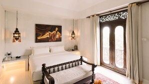 A bedroom with a large bed, two bedside tables, a painting on the wall, and a window with curtains. - At Niman Conceptual Home (Chiang Mai)