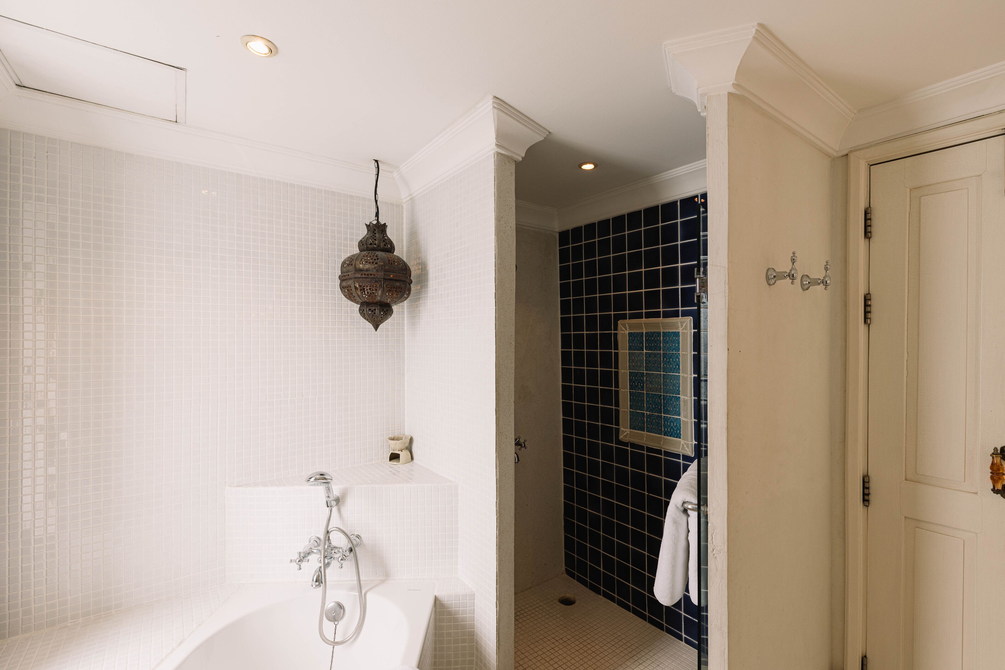 A bathroom with a bathtub, a shower, and a tiled wall.
