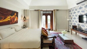 A bedroom with a large bed, a desk, a television, and a decorative painting. - At Niman Conceptual Home (Chiang Mai)
