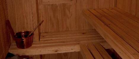 Una sauna de madera con bancos y un asiento.