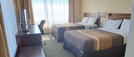 Una habitación de hotel con una cama grande, un escritorio y una zona de estar.