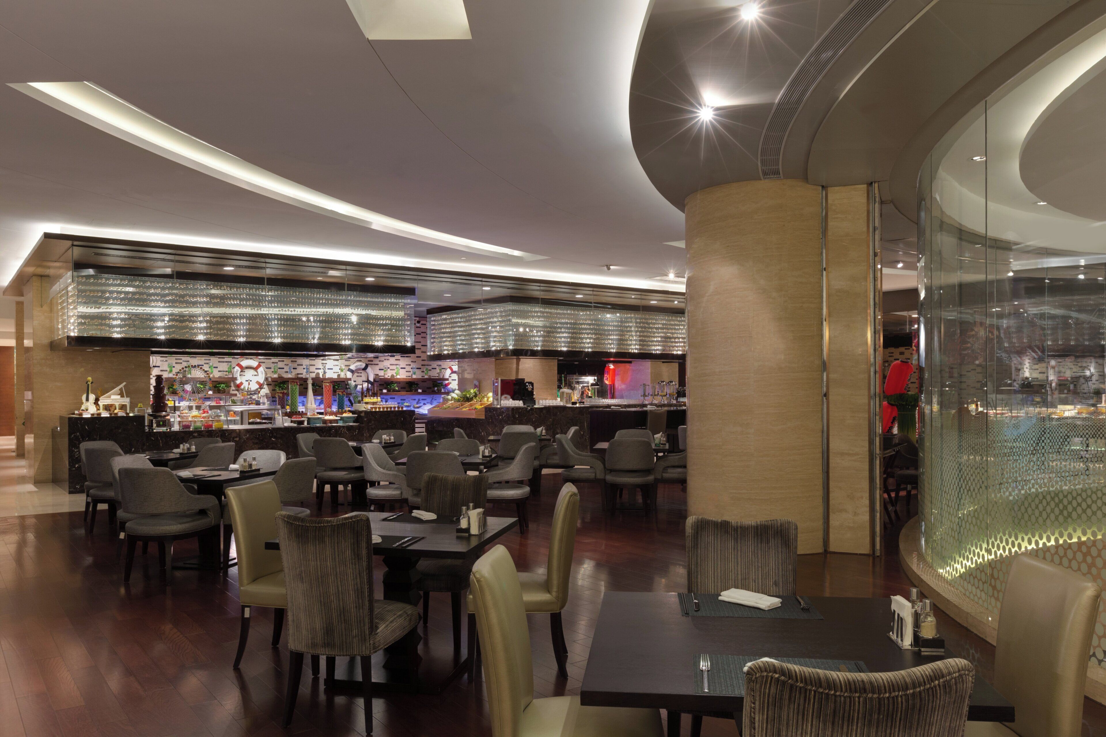 Ein modernes Restaurant mit Barbereich, verschiedenen Sitzgelegenheiten und einem zeitgemäßen Interieur.