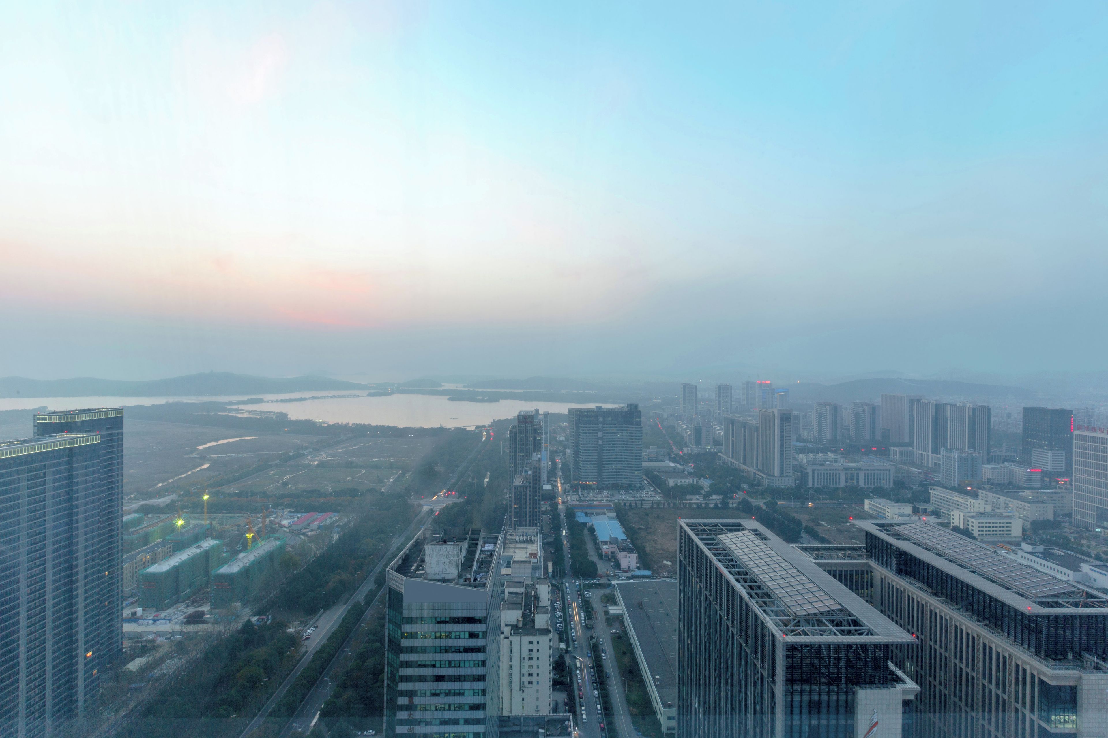 A cityscape with high-rise buildings, a river, and a bridge.