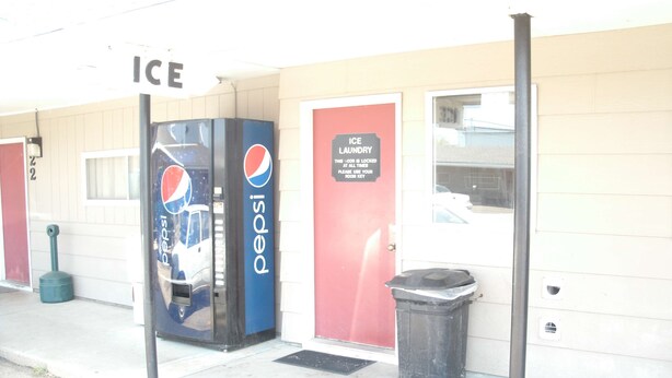 A building with an 'ICE' sign, a Pepsi vending machine, and an 'ICE LAUNDRY' sign. - Rainbow Motel Hastings (Hastings)