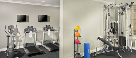 Una palestra con tapis roulant, una panca per pesi e diverse attrezzature per esercizi.