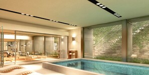 A modern indoor swimming pool with clear glass walls, exercise equipment, and a view of a stone wall and greenery outside. - Flaat Apartamentos Del Polo (Buenos Aires)