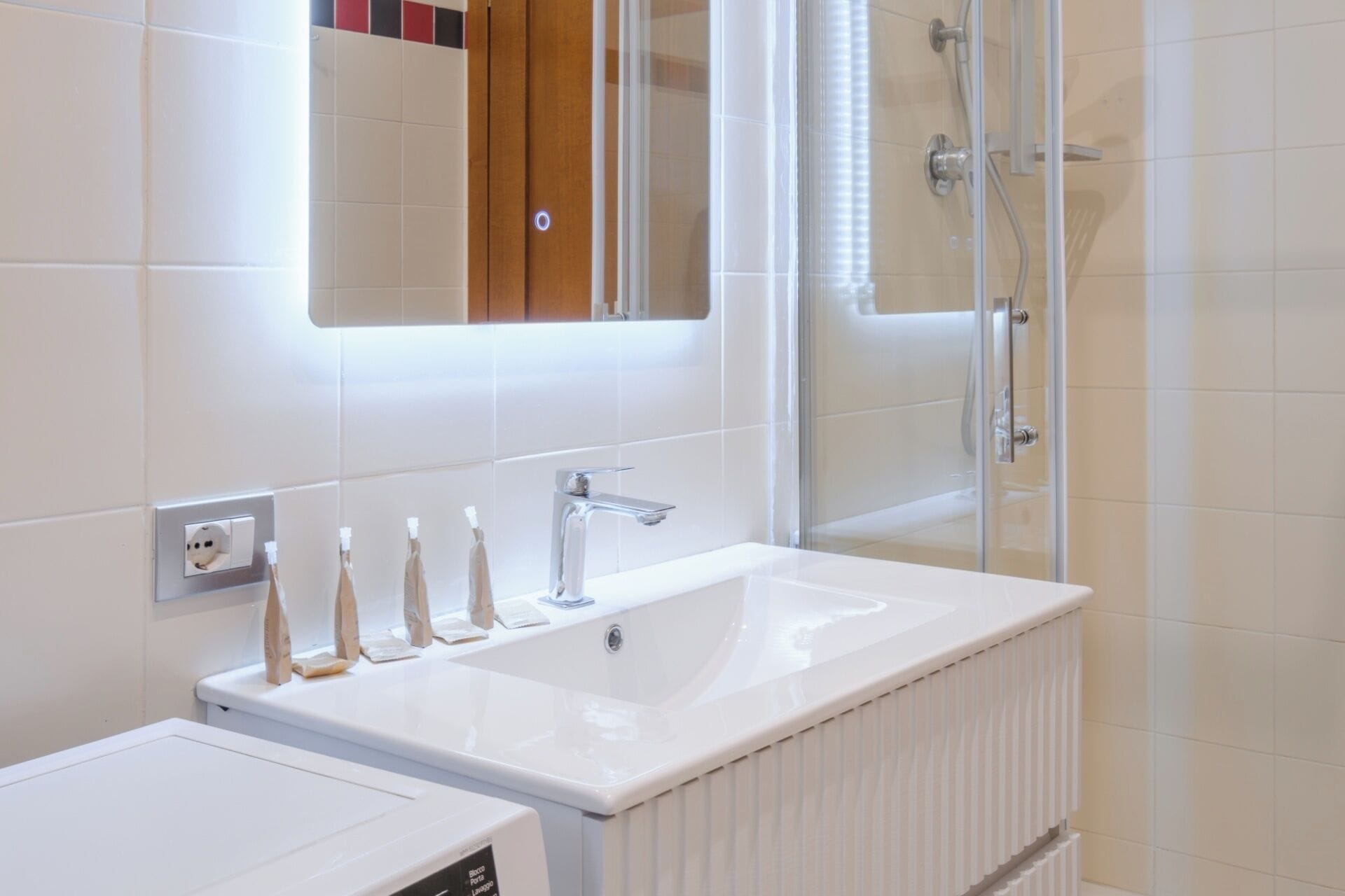 Une salle de bain moderne avec un lavabo blanc, un miroir et une douche.