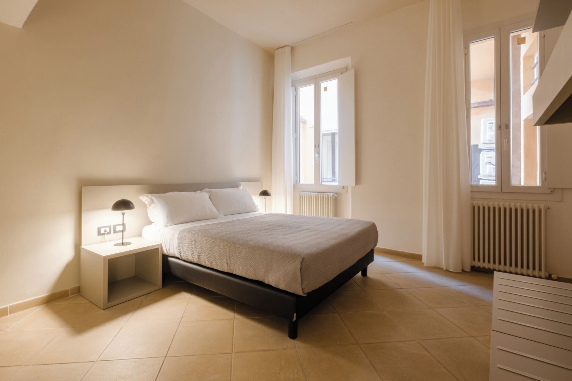 Une chambre à coucher avec un lit, une table de chevet et un radiateur.