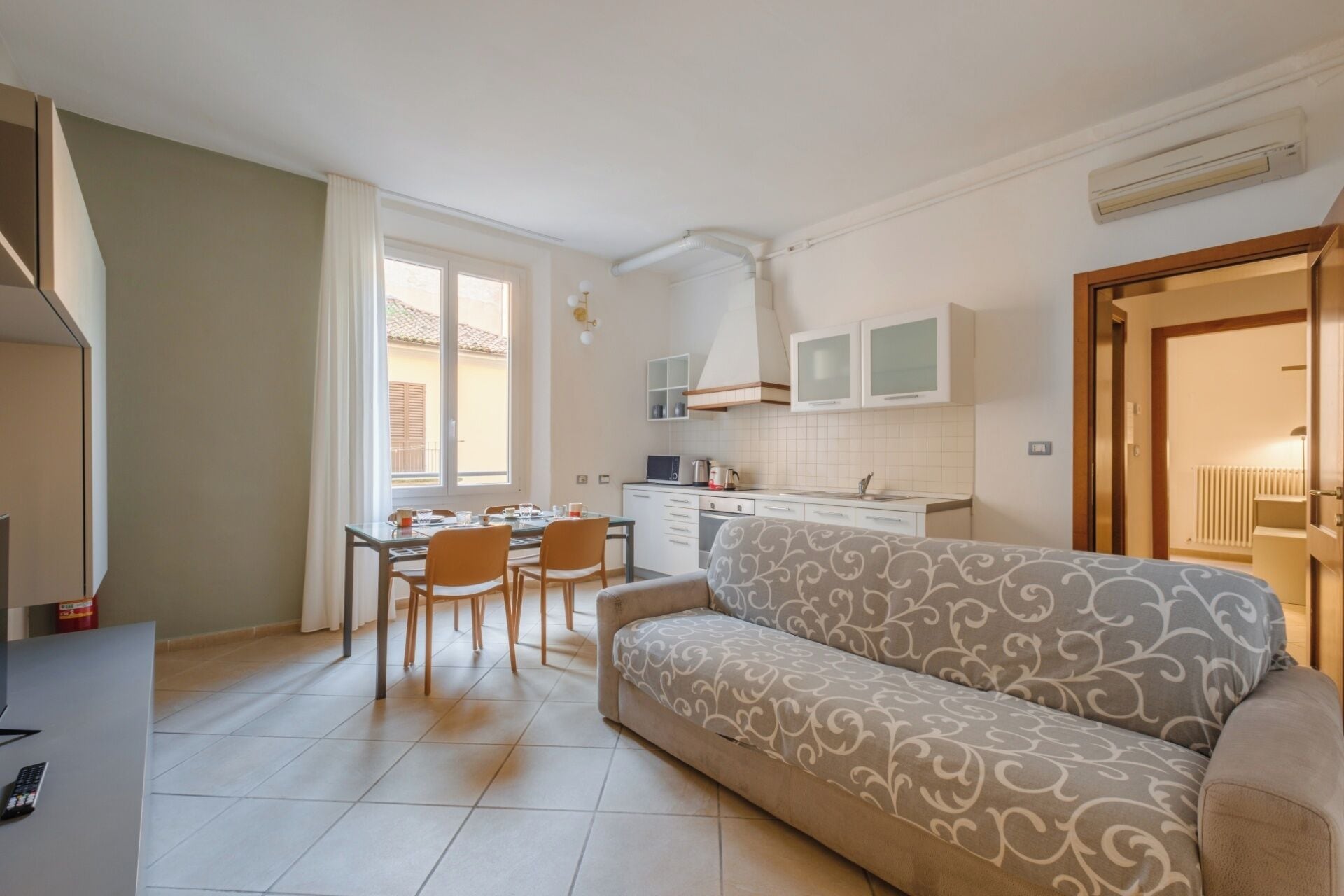 A compact living space with a kitchenette, a dining area, and a sofa.
